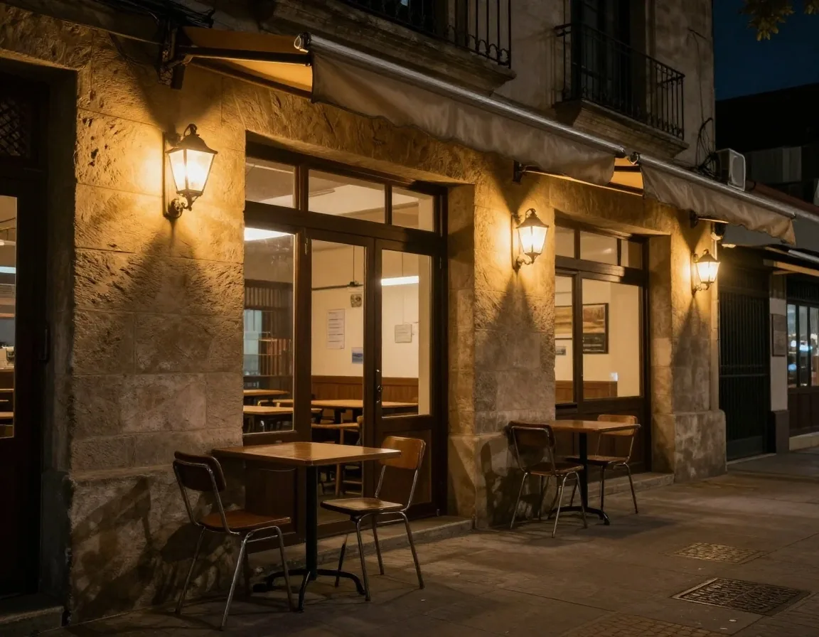 Banco de terrazo bajo una lámpara ámbar en el taller nocturno